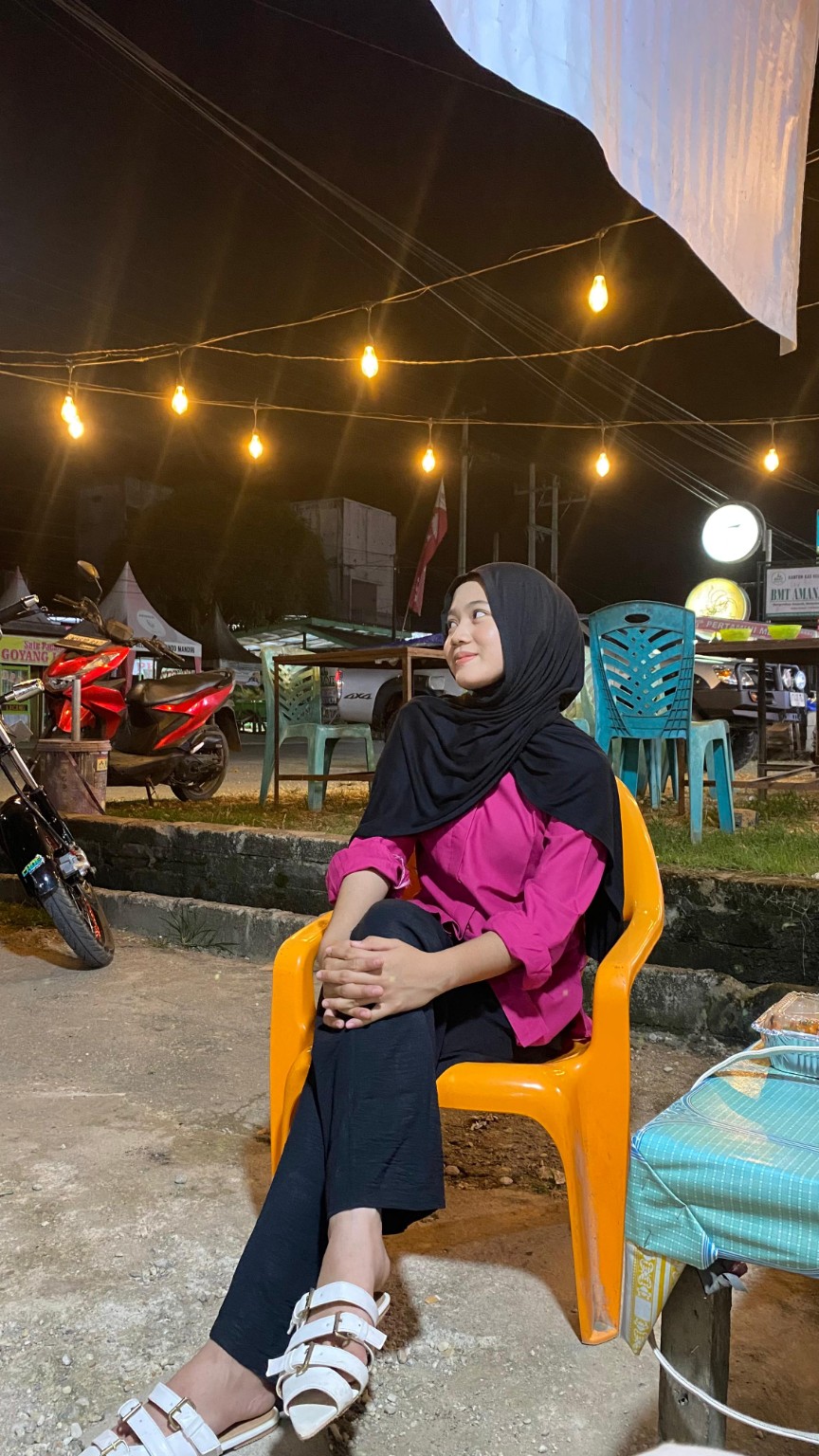 Foto Jesika memakai hijab hitam dan baju pink di malam hari